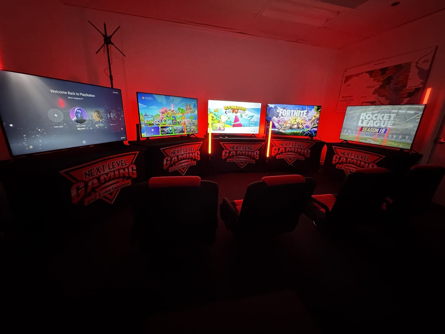 A Next Level Gaming mobile arena in a dark room with red LED lighting and a row of big screens in the DMV