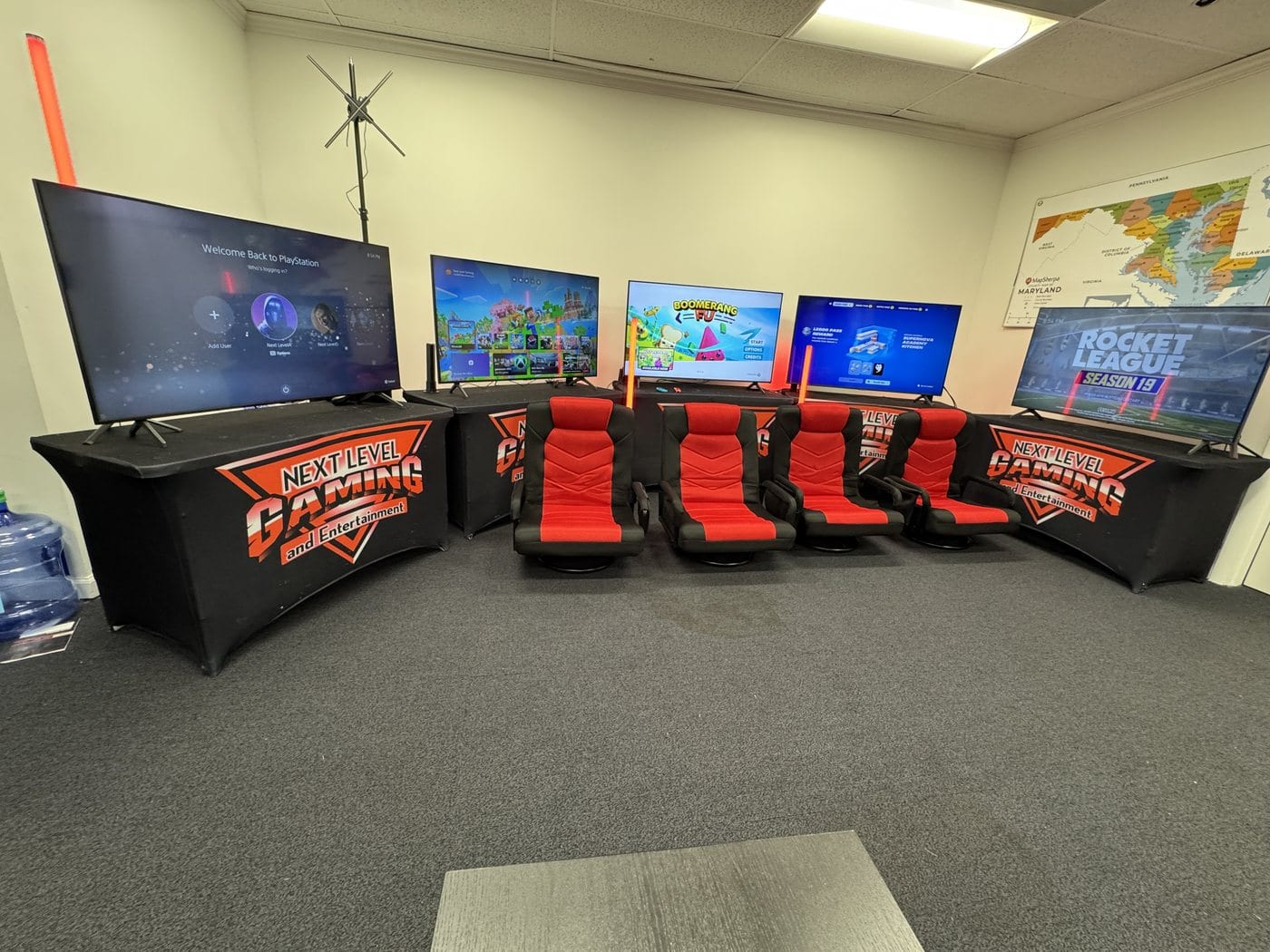 A Next Level Gaming mobile arena set up indoors with red gamer chairs and big screens in the DMV