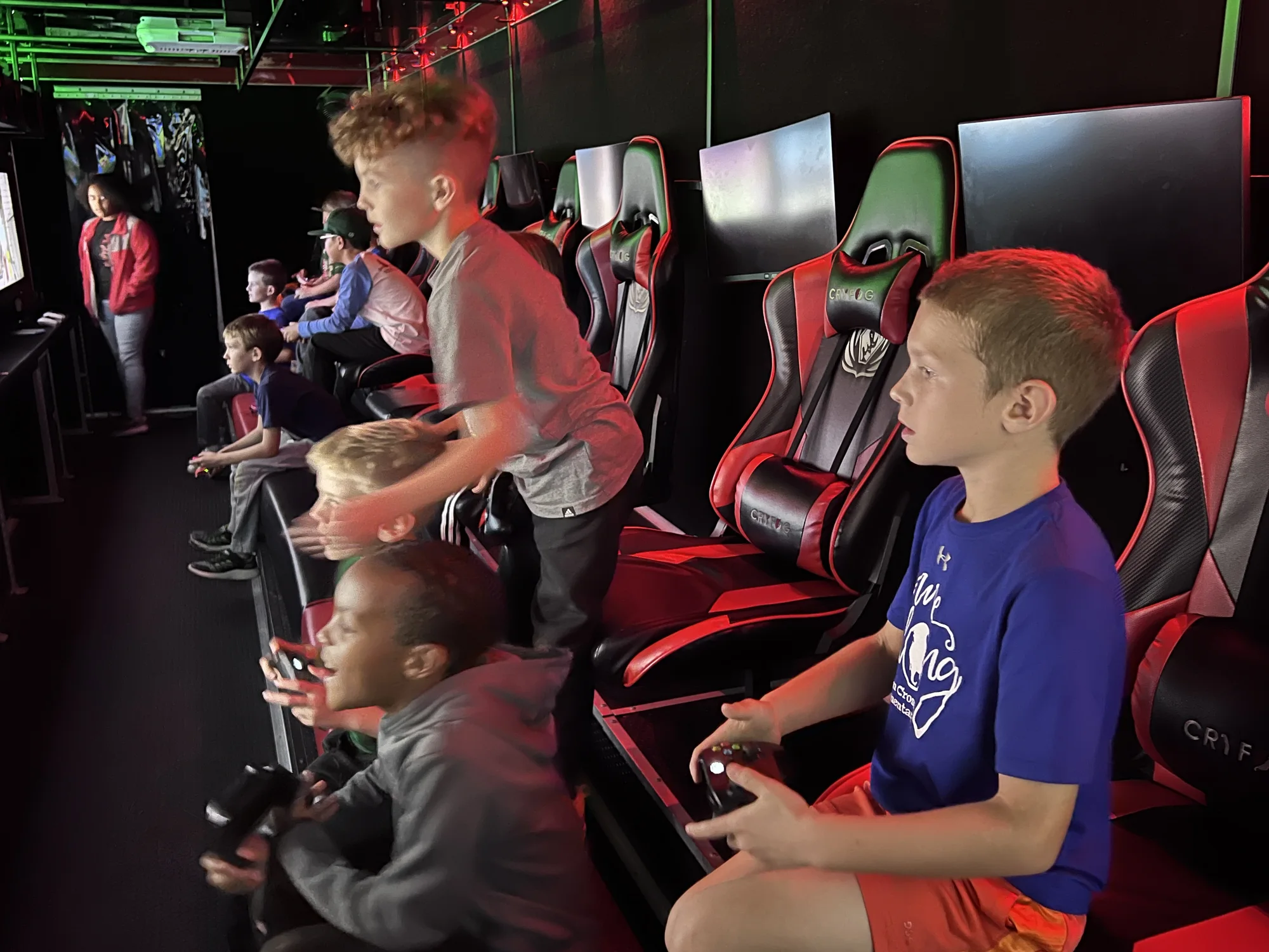 A crew playing together across multiple gaming stations inside the theater