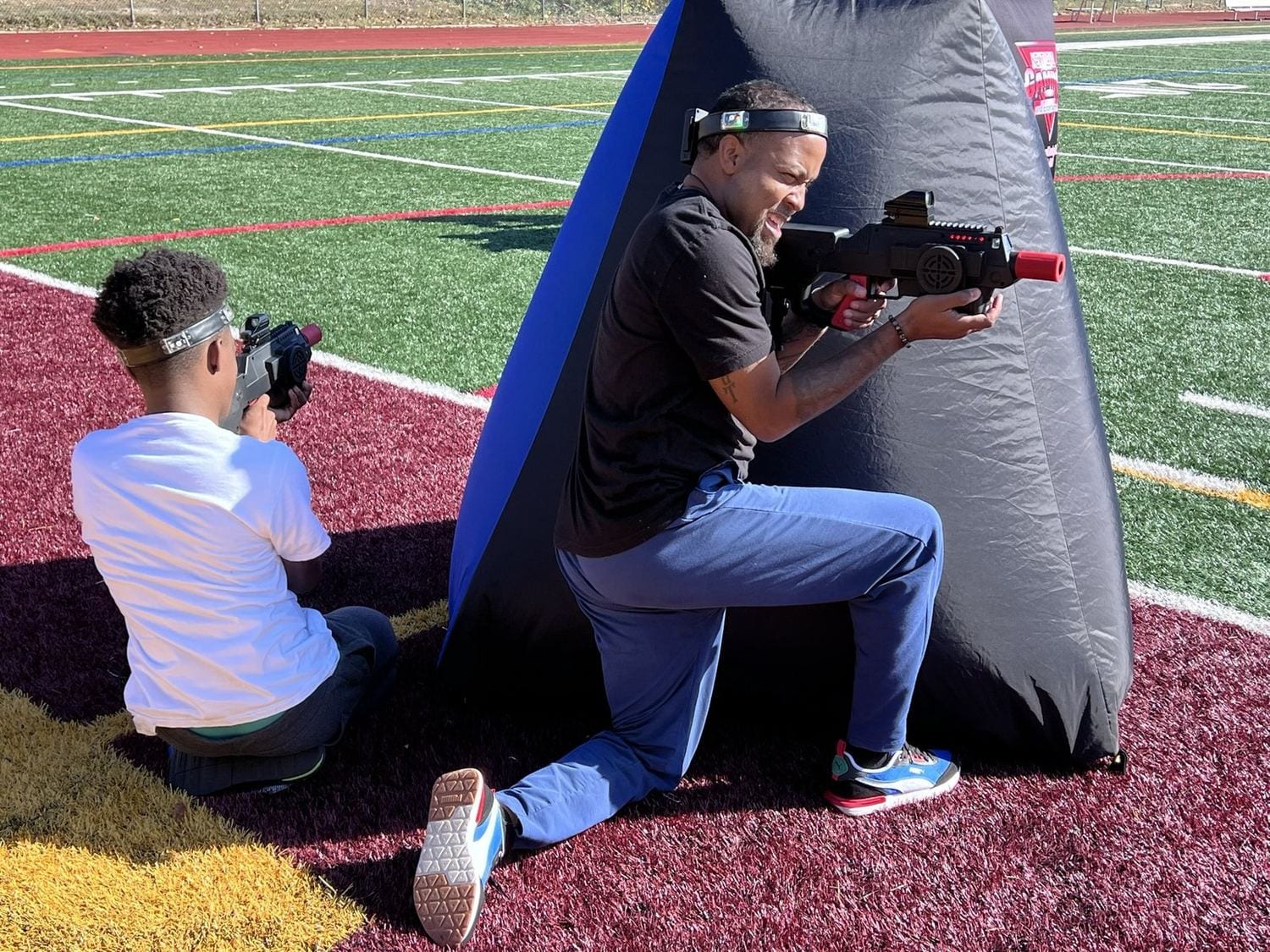 Players in an outdoor laser tag match on a turf field at a Next Level Gaming event in the DMV