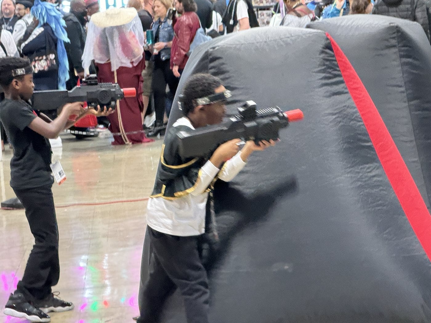 Players in a mobile laser tag match with inflatable obstacles