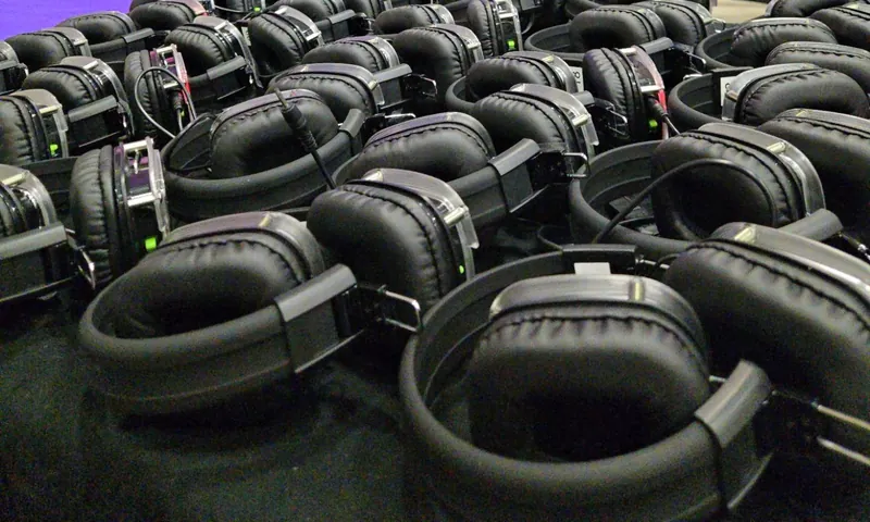 Rows of wireless headphones laid out ready for a silent party.