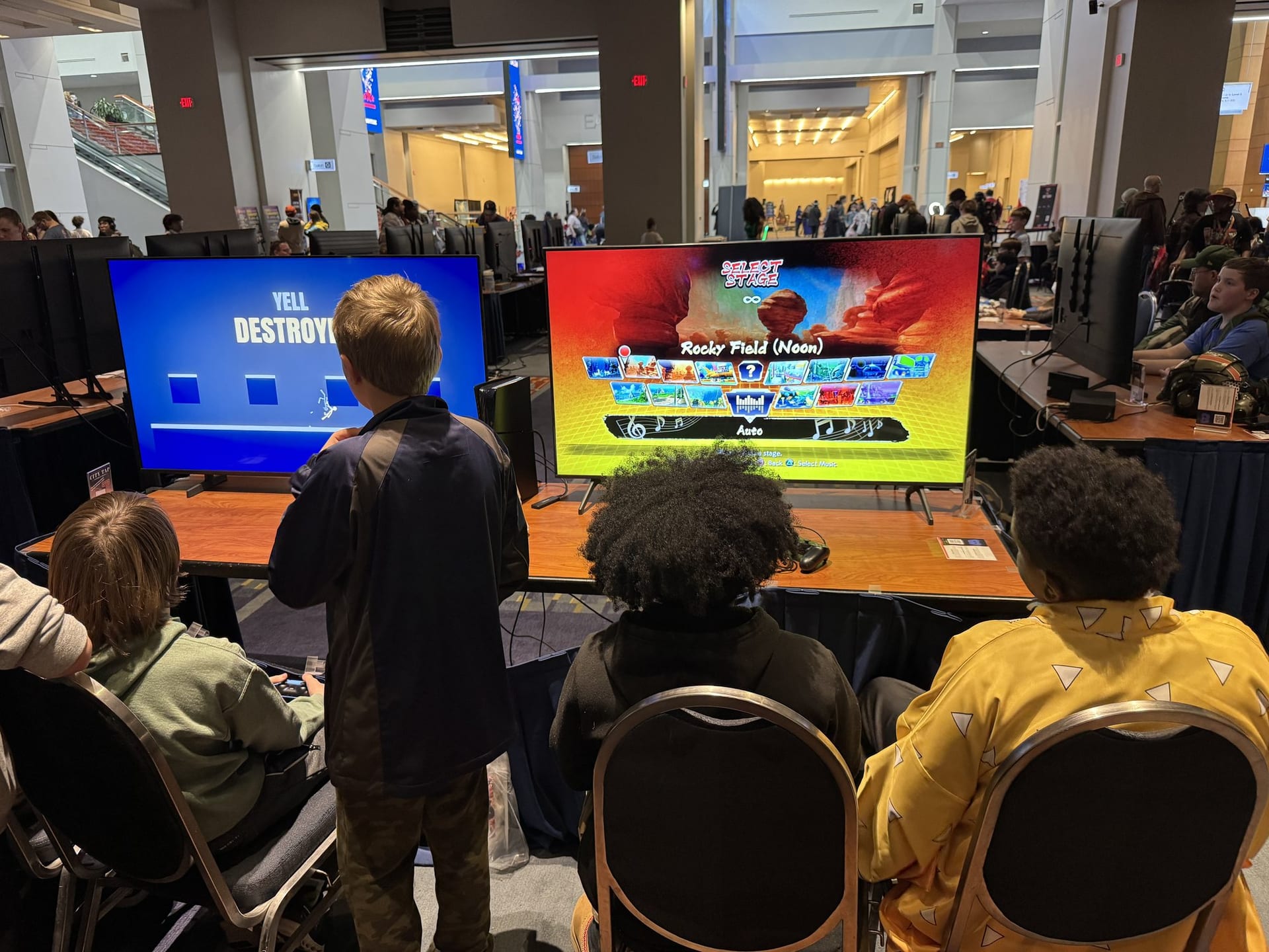Rows of screens and a crowd of players at a large Next Level Gaming activation.