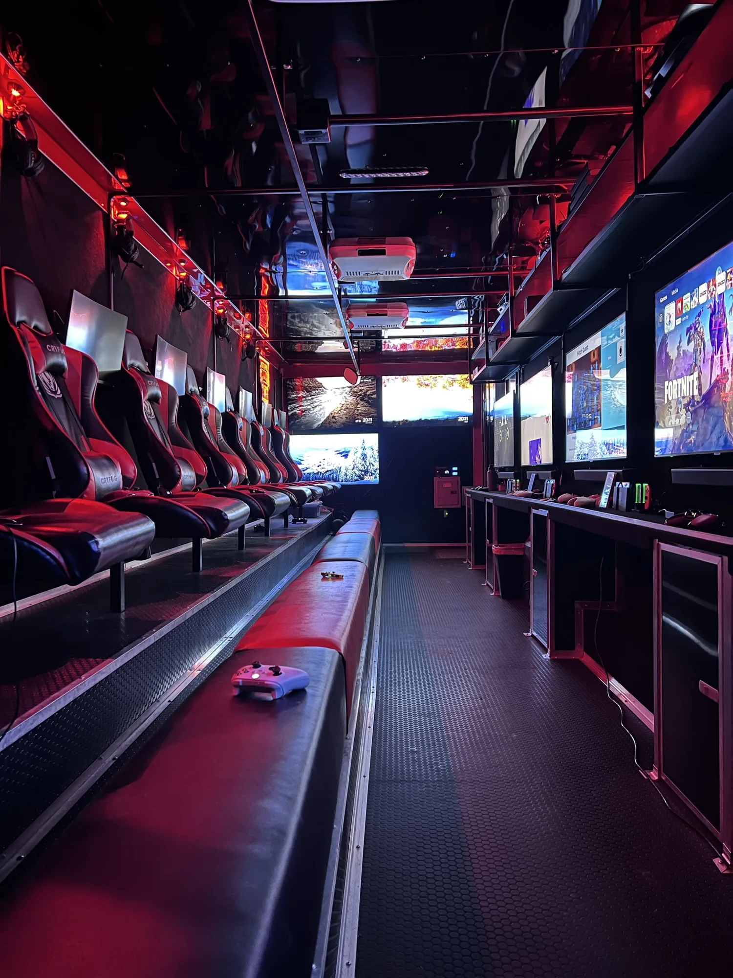 Empty game theater interior with gamer chairs, screens and red lighting