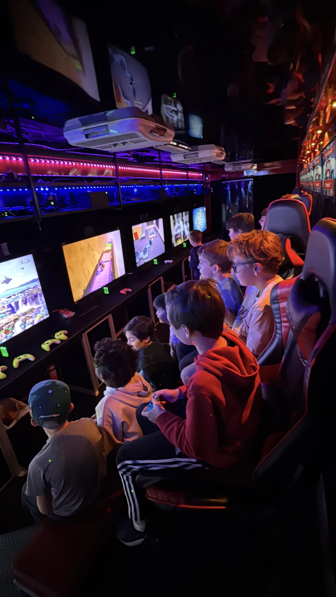 A full group playing inside the theater with several screens running